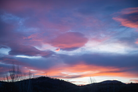 Colorful sunset sky with dramatic clouds over mountain horizon