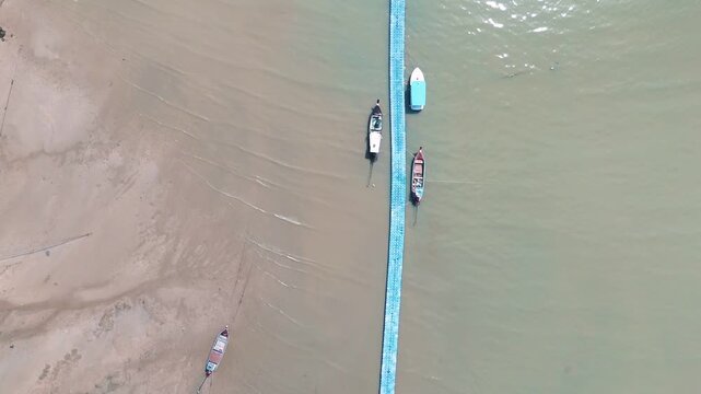 Top down aerial turquoise sea water texture and fishing boats on dock in Phuket Thailand