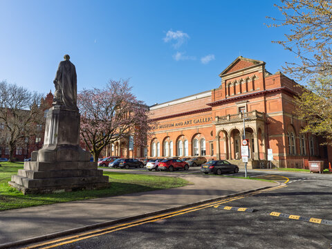 Salford Manchester. Historic art museum with a statue in a tranquil urban setting.