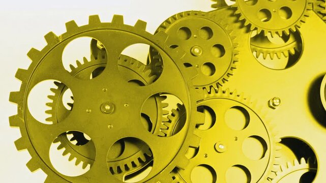 Close-up of golden metal gears rotating in a mechanical system. Luxury industrial concept with interlocking cogwheels, precision engineering and smooth motion.