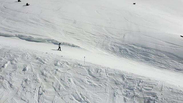 aerial view of snowboarder sliding down a snowy mountain