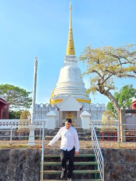 Man standing in front of white golden pagoda at Tangkuan Hill temple landmark in Songkhla, Thailand