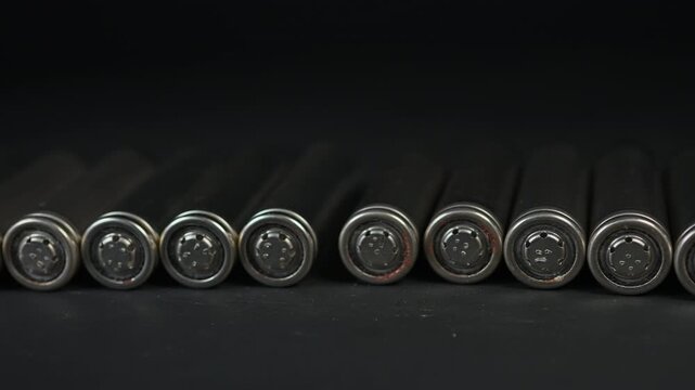 Silver AA batteries type on black matte background as an example of rare earths metals use in magnets, smart devices, electric vehicles and are hard to mine and separate cleanly.