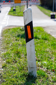Roadside delineator with reflector marking rural road curve
