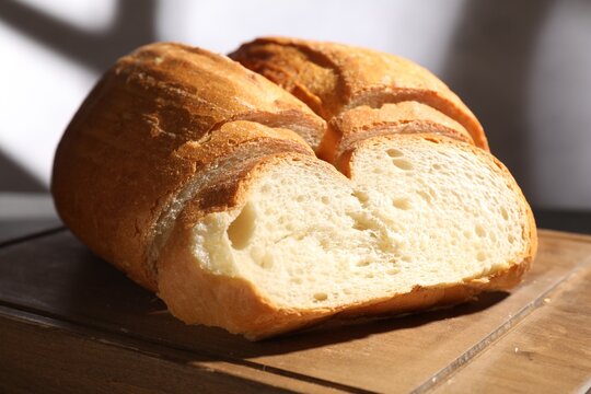 Pieces of fresh bread on wooden board, closeup