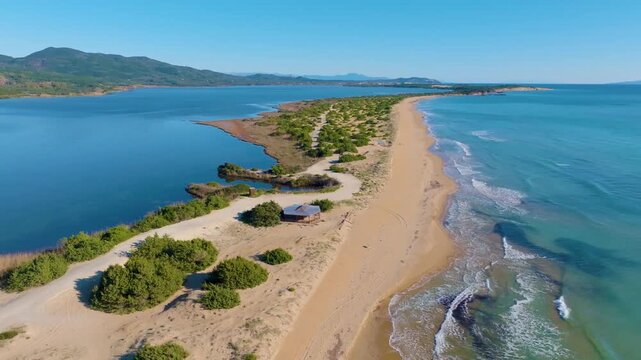 High altitude drone view of the unique sandy coastline of Halikounas beach and cedar forest dunes separating the wetlands from the Ionian sea in Corfu
