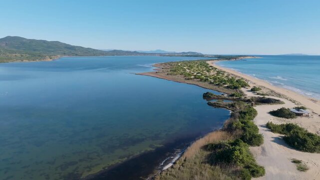 Aerial panorama of Halikounas beach and Korission lagoon showing the narrow strip of sand separating the lake from the sea in Corfu Greece nature reserve