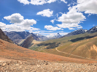 Fototapeta premium Vast Arid Valley with Winding Mountain Road on the Approach to Singe La Pass, Ladakh