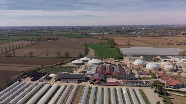 Drone view of mixed farming with livestock and greenhouses. Rural environment combines animal husbandry and plant production in a sustainable agricultural system.