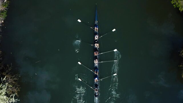 Rowing team training on a river, with athletes synchronizing their strokes for optimal speed