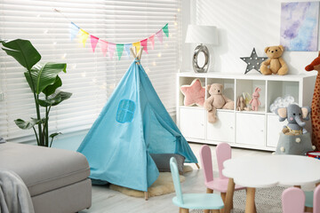 Child's room with furniture, toy wigwam, toys and colorful flags. Interior design © New Africa
