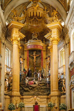 Close view of the baroque altar inside Bom Jesus do Monte sanctuary in Braga, Portugal, with gilded columns, crucifixion figures and elaborate religious decoration.
