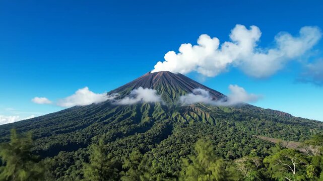 Majestic active volcano emitting white smoke under a clear sky