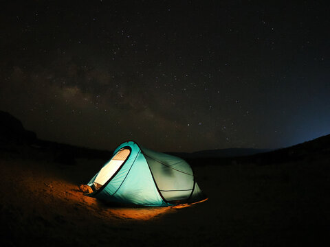 Glowing tent under starry night sky on Socotra island copy space