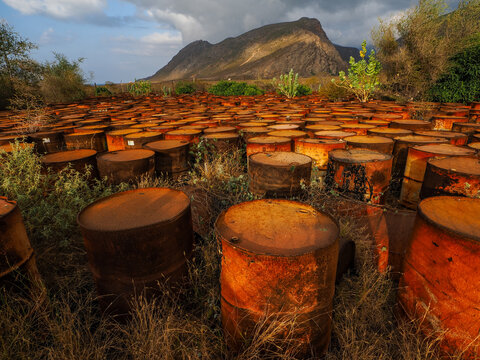 Rusty oil drums field Socotra environmental pollution copy space
