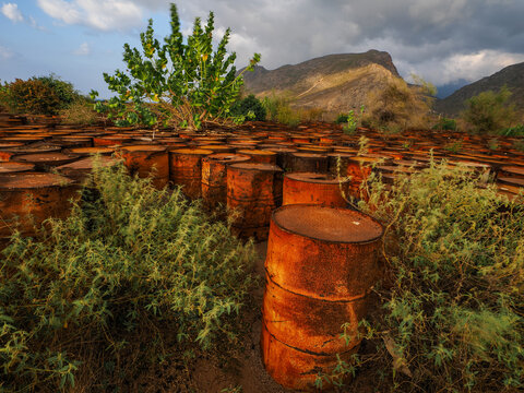 Rusty oil drums field Socotra environmental pollution copy space