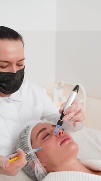 Peeling, woman health care, skin regeneration, dermapen microneedling, dermastamp. Beautician cosmetologist doing forehead face procedure fractional microneedle mesotherapy clinic facial rejuvenation