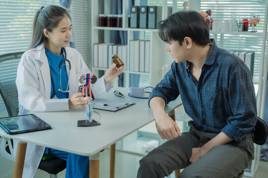 A male doctor sits at his desk in a hospital, talking to a male patient about various urinary tract conditions in men, such as prostatitis and cystitis.