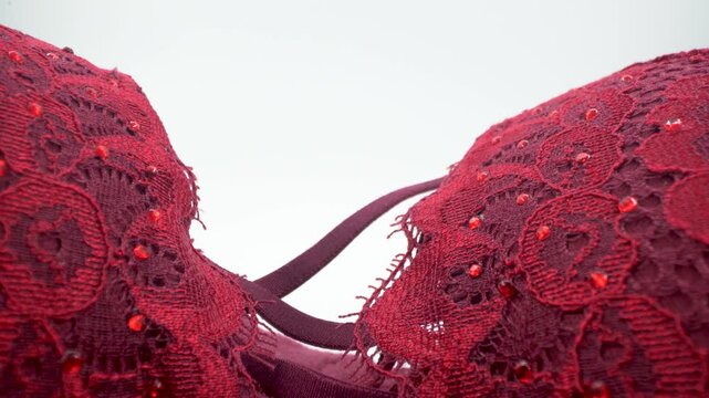 Close up of red lace bra with decorative bead details.