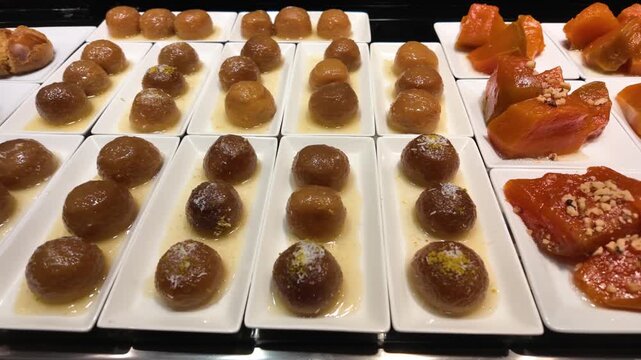 Variety of traditional turkish desserts including kemal pasa and pumpkin sweets displayed in hotel buffet.