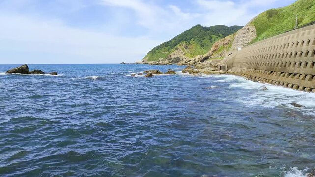 日本海の庄内海岸でコンクリートブロックに打ち寄せる波の風景
