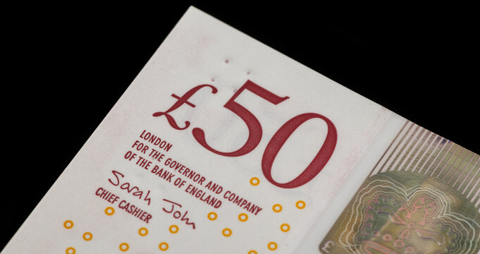 A fragment of a 50 British pound note on a black background