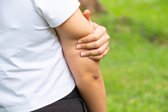 Woman has pain in his elbow and tendon muscles and he relieves the pain with a massage. Health and healing concept	
