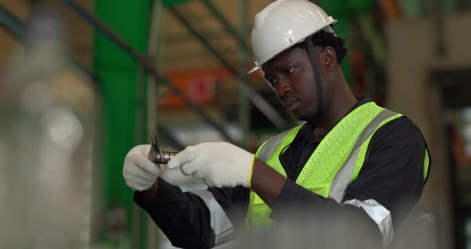 Factory technician uses a vernier caliper to measure a metal component during dimensional inspection in a manufacturing facility, showing quality control, tolerance checks, and process verification.
