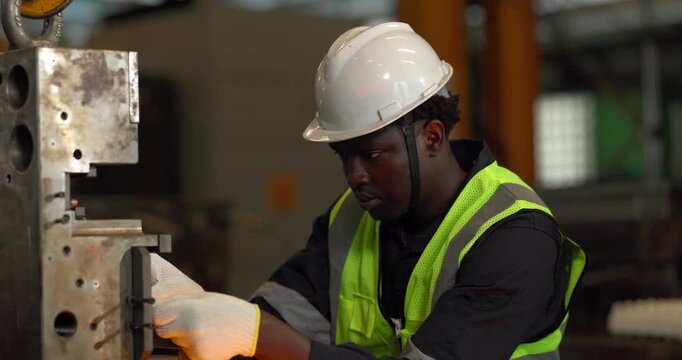 Factory technician uses a vernier caliper to measure a metal component during dimensional inspection in a manufacturing facility, showing quality control, tolerance checks, and process verification.
