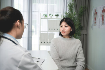 Obraz premium Woman sits calmly, facing doctor in clinical setting. medical consultation concept