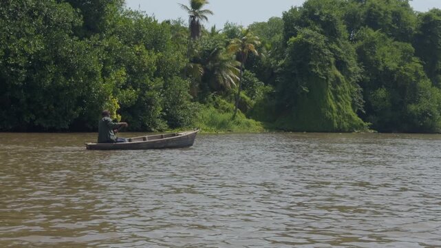 Wooden canoe on Lake Maracaibo with tropical shoreline, Venezuela