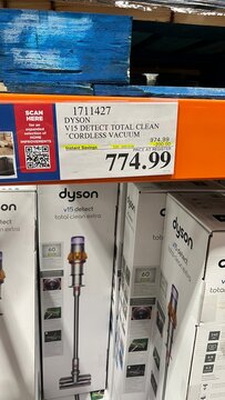 Dyson V15 Detect Total Clean cordless vacuum displayed in Costco shopping warehouse, showcasing pricing and product details for consumer convenience and shopping experience