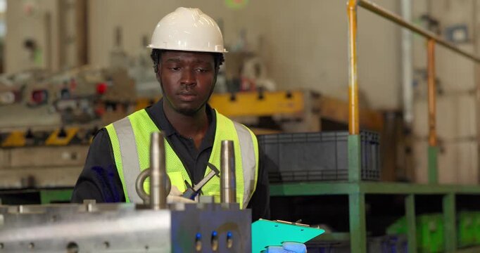 Factory technician uses a vernier caliper to measure a metal component during dimensional inspection in a manufacturing facility, showing quality control, tolerance checks, and process verification.
