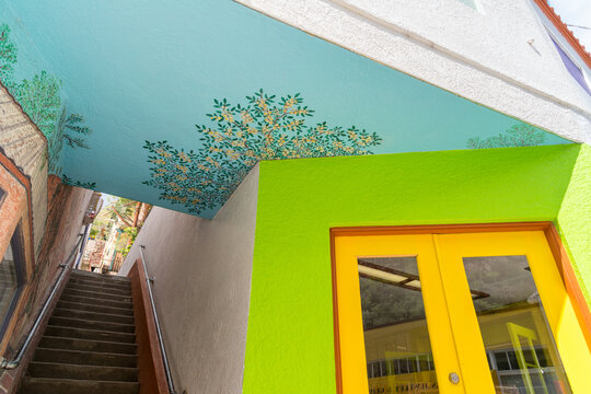 USA, Arizona, Bisbee.  Colorful, painted stairway leading up between buildings on the main street.