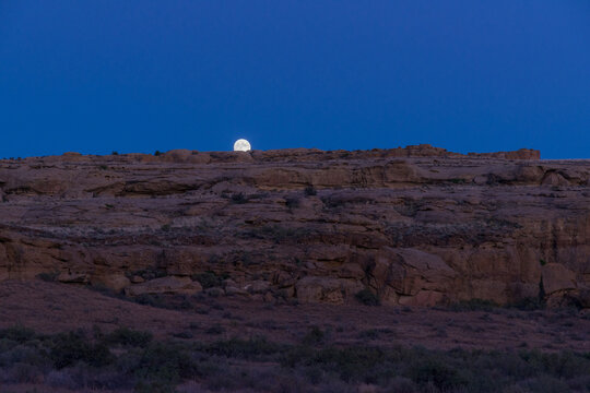 USA, New Mexico, Chaco Canyon.  The moon rising over cliff on the east rim of the canyon.