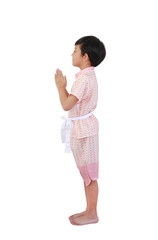 Charming young Asian boy dressed in traditional pink Thai costume performing the "Wai," a respectful Thai greeting gesture, while standing against white background. Side view. © zilvergolf