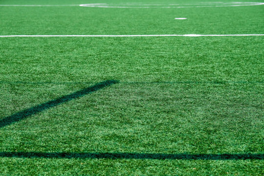 Soccer field with green grass and white line, sport background.