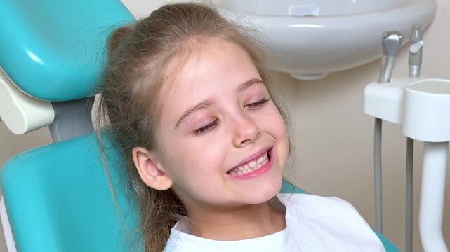 Little girl sitting in dentist chair showing her teeth to doctor. Baby teeth concept. Beautiful smiling preschool girl lost baby tooth. Dental hygiene concept