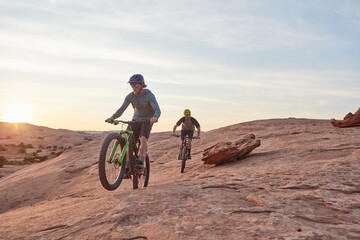 Men, mountain bike or cycling with sunset on dirt hill in dunes for extreme sport together. Active, male people or cyclist riding with bicycle for outdoor challenge or adrenaline rush in wilderness © peopleimages.com