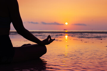 meditation on the beach, mindfulness background with copyspace, yoga closeup at sunset