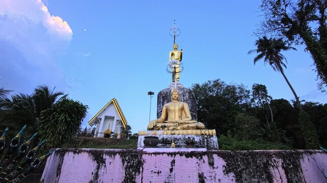 Twin naga serpent statues overlooking calm coastal water at sunrise in Thailand