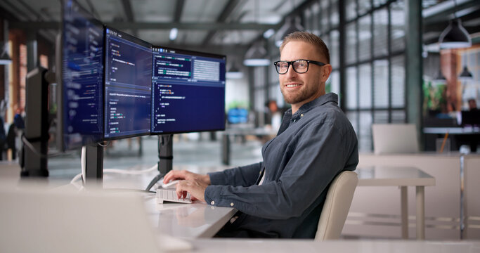 Joyful Software Developer Coding With Several Screens