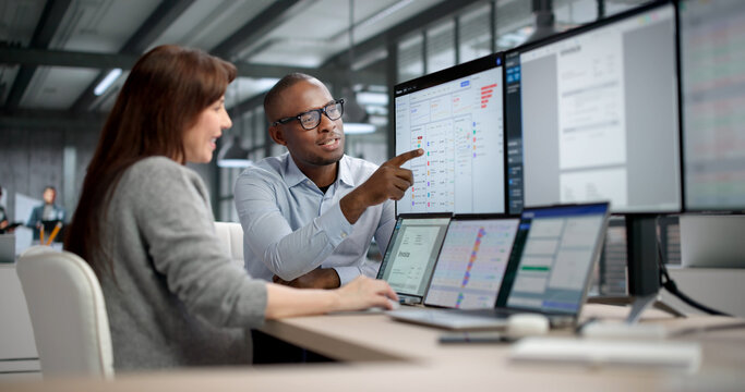 Two Professionals Analyzing Financial Reports And Tracking Data