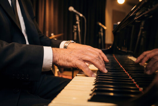 Musician skilled hands elegantly playing the black keys of a grand piano