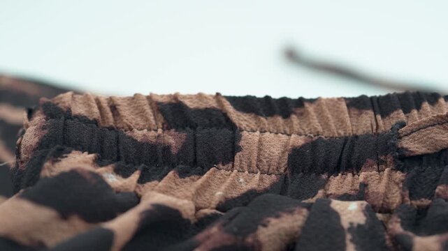 Close up of leopard print fabric texture with soft folds and pattern.