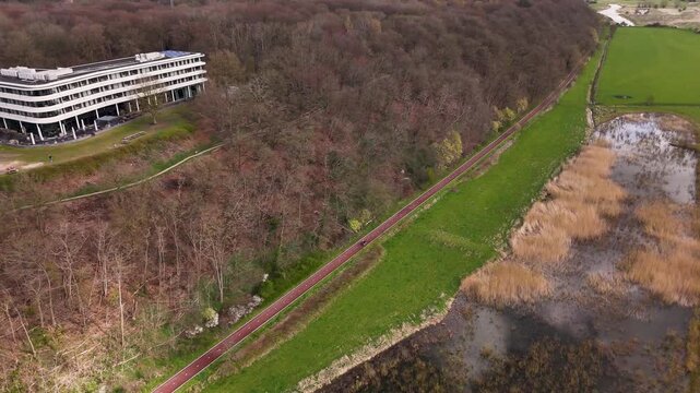 Aerial view of a bike path between woods and a wetland area