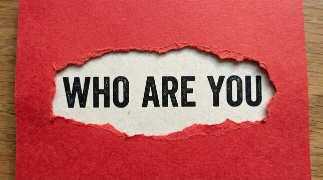 Red paper torn open at center revealing bold black text &ldquo;WHO ARE YOU&rdquo; on white background, dramatic contrast creating sense of curiosity, introspection, and striking visual emphasis on hidden message.