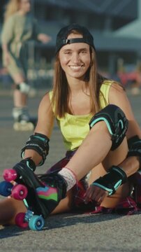 Casual young woman buckling onto her skates, Youthful female adjusting rollerblades in sunny park setting