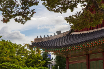 Fototapeta premium Majestic Korean palace architecture with symmetrical stone courtyard and layered tiled roof under dramatic sky, traditional Asian heritage landmark, cultural travel destination concept