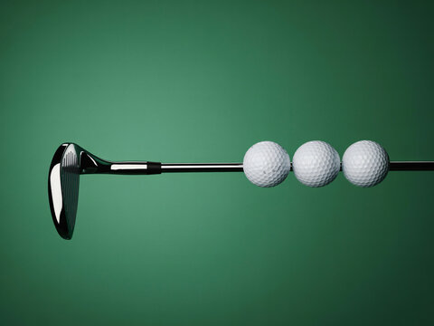 A golf club with three white golf balls on a green background